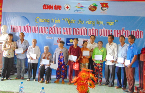 Ông Ngô Huỳnh Quang Thái - Phó Bí thư Thường trực Tỉnh Đoàn trao quà cho bà con nghèo xã Tân Phước